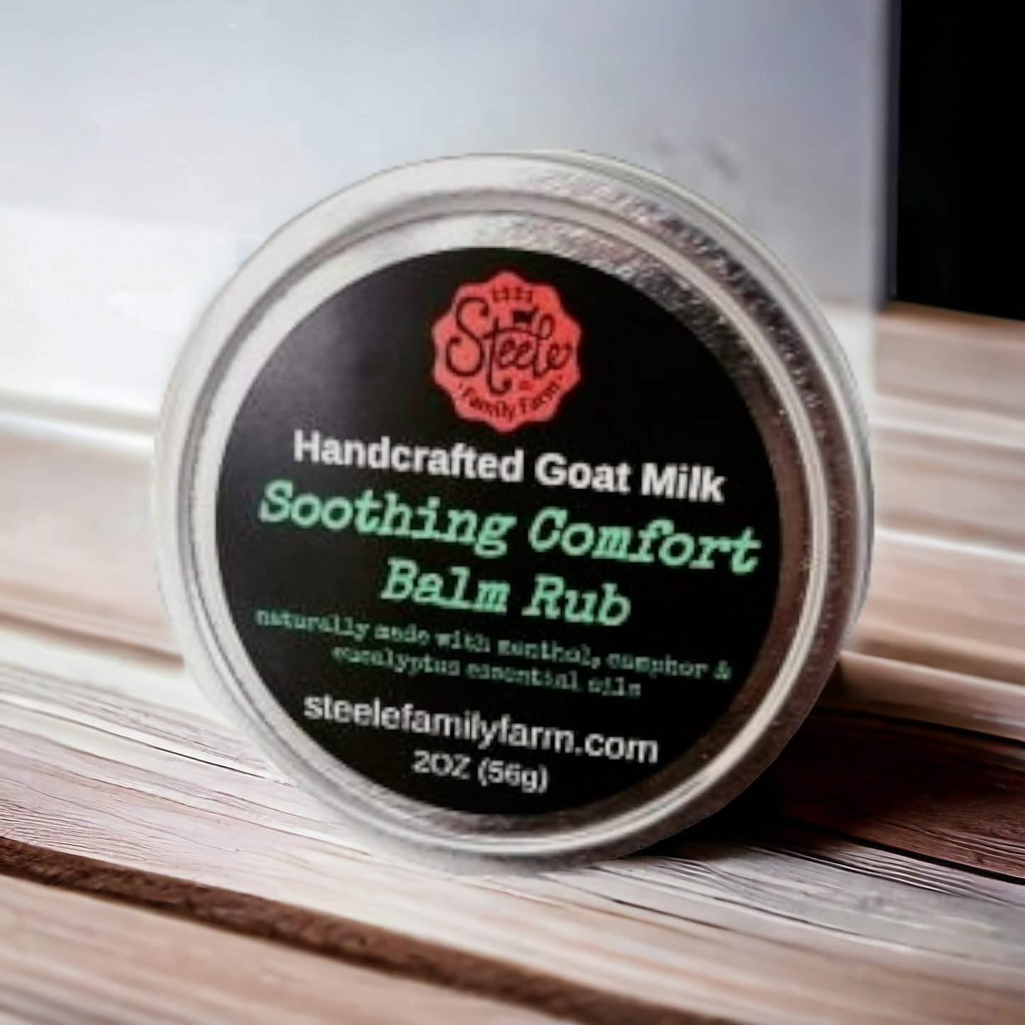 Handcrafted Goat Milk Soothing Comfort Balm Rub container with label on a wooden surface