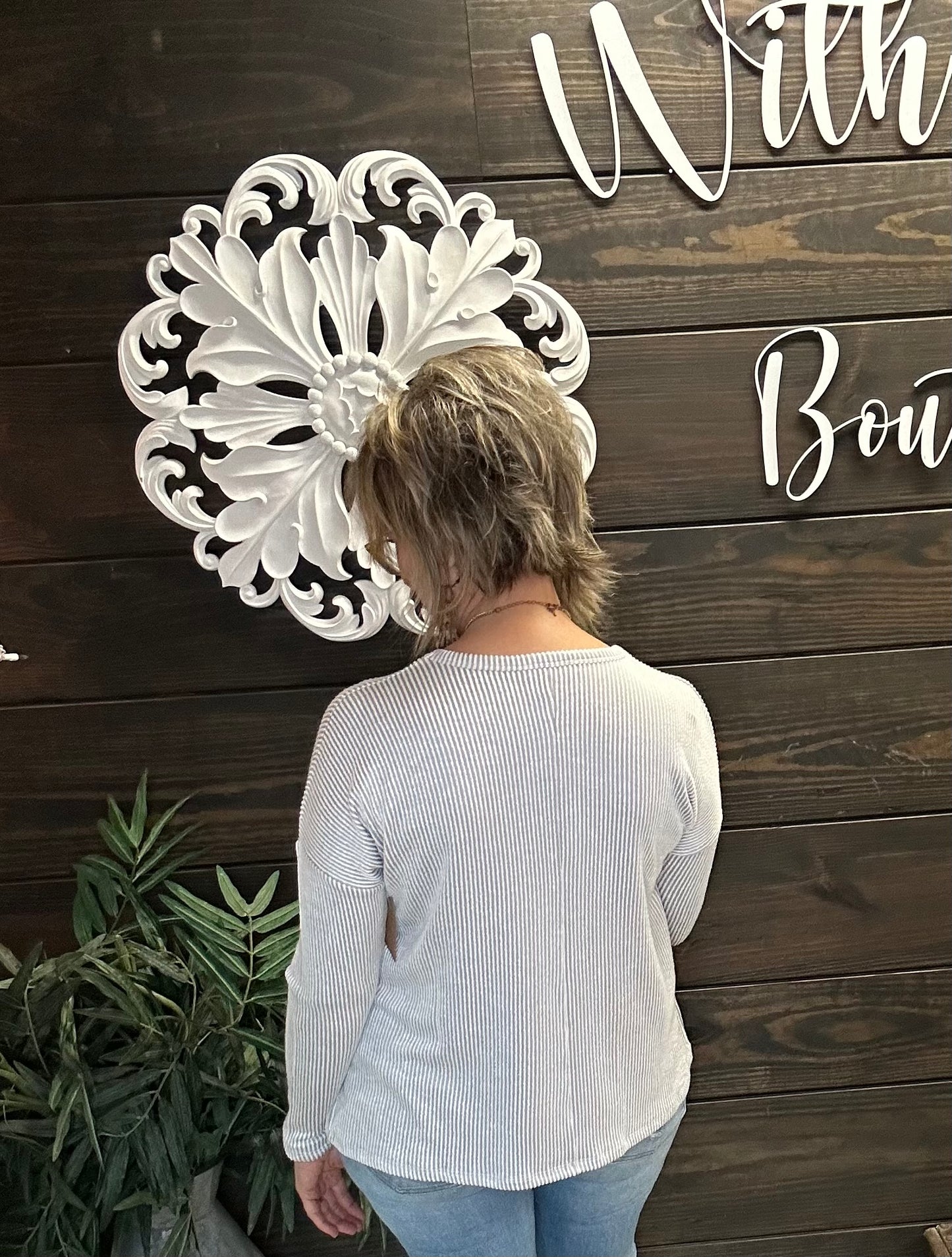 back of a woman in a light grey ribbed long sleeve top