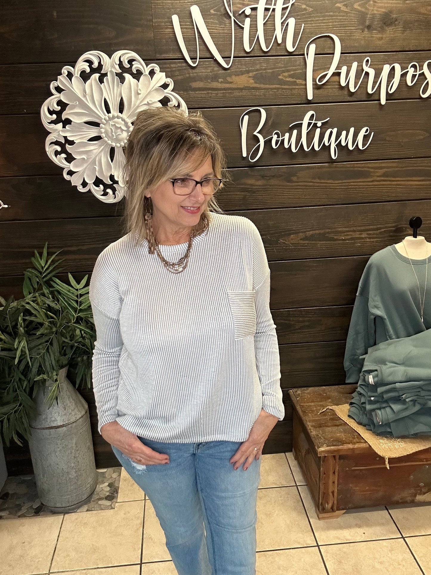women wearing a ribbed top in light grey with a front pocket