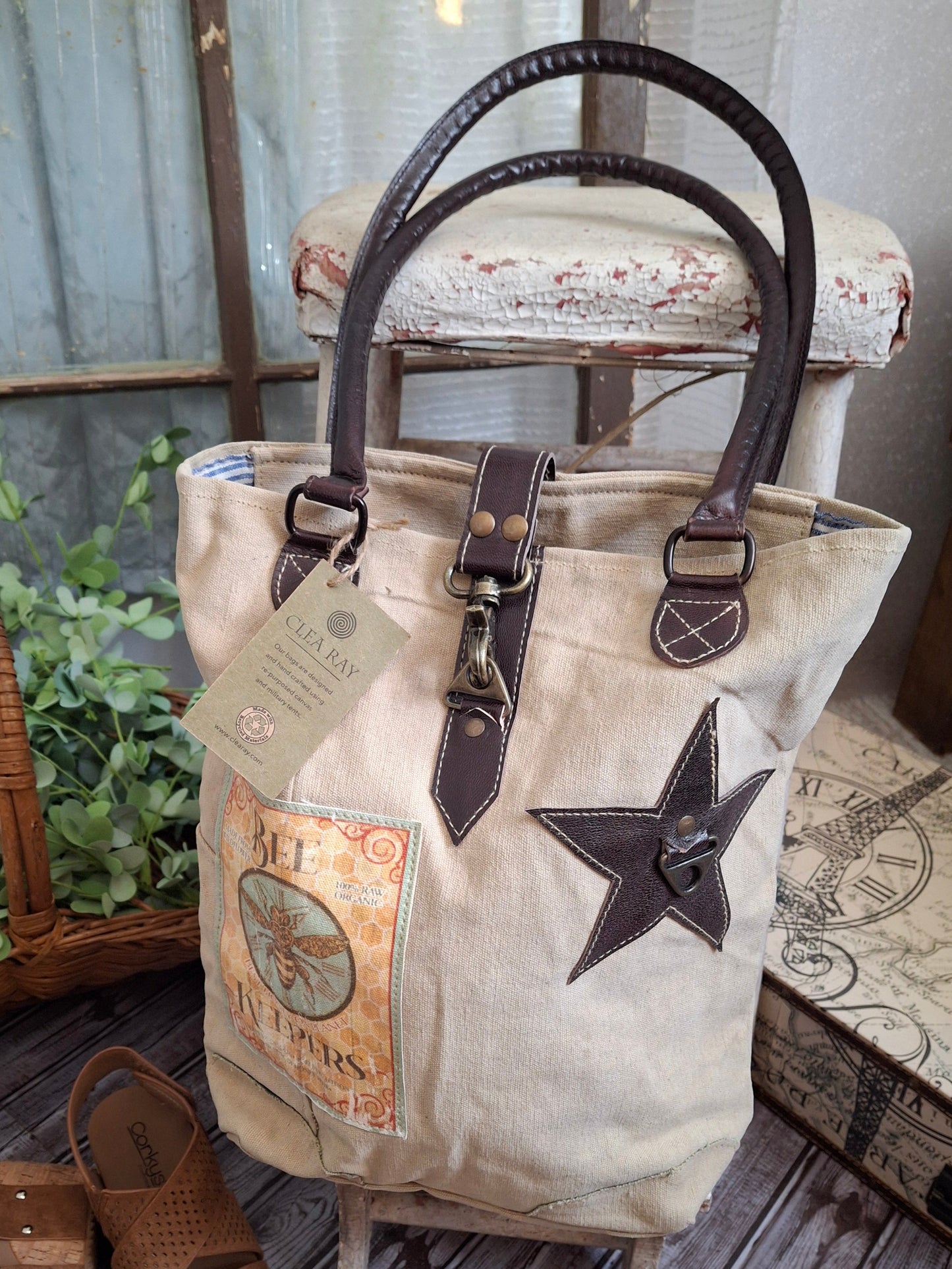 Manufactured in USA/Hand Crafted
This uniquely charming tote is crafted from upcycled canvas for a vintage vibe. Attention to detail shows in the quality, including lobster claw clips and a back zippered pocket, star applique and bee patch inlay! .
Bags made from upcycled canvas such as repurposed military tents & more
approx:10 x 14 x 3.5