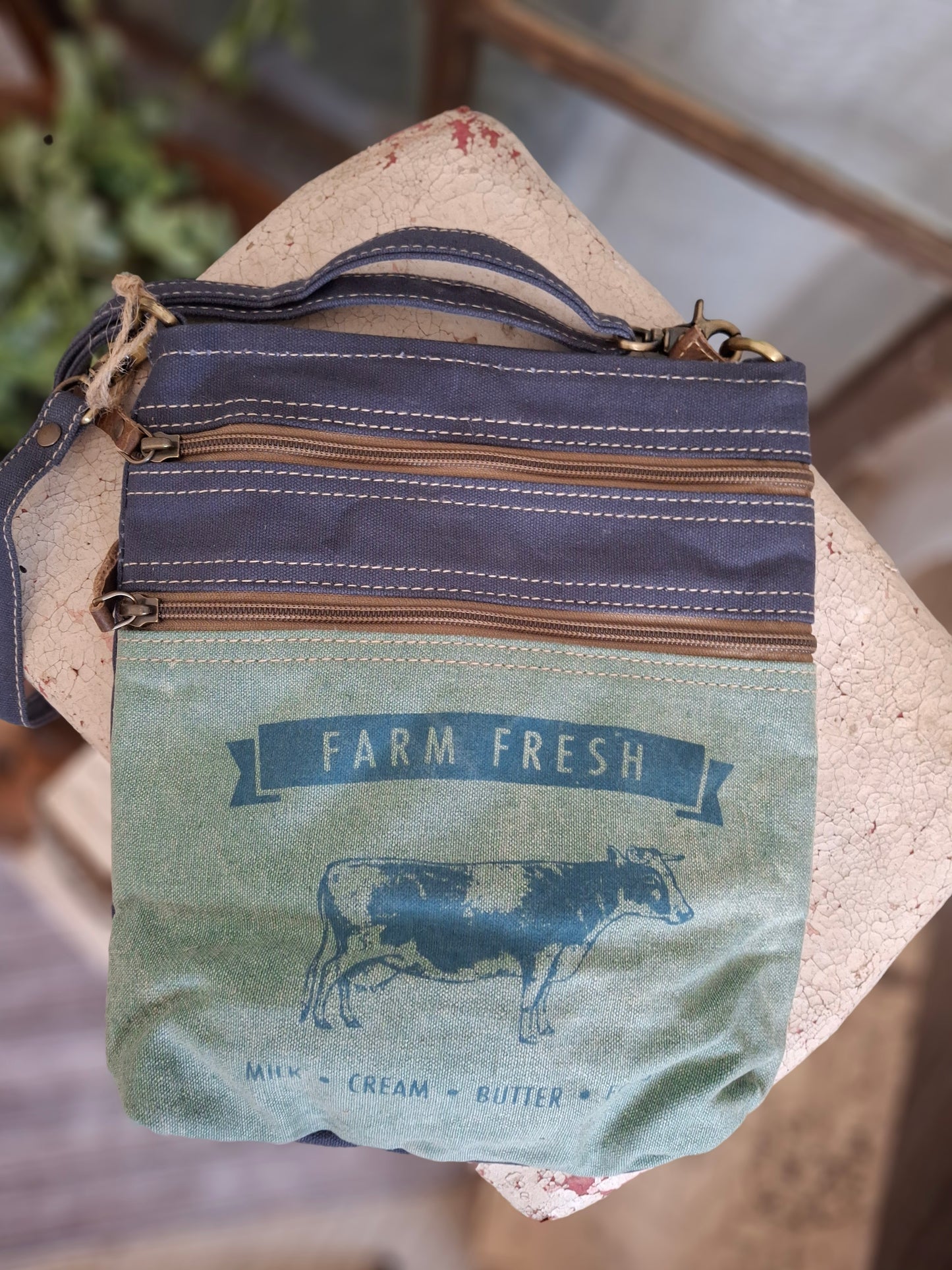 Paying tribute to retro advertising, this cute Farm Cow crossbody is on point! It features a vintage blue and white stripe lining, one inside pocket, three outside zippered pockets, and an adjustable shoulder strap.
Designed & Manufactured in USA/Hand Crafted