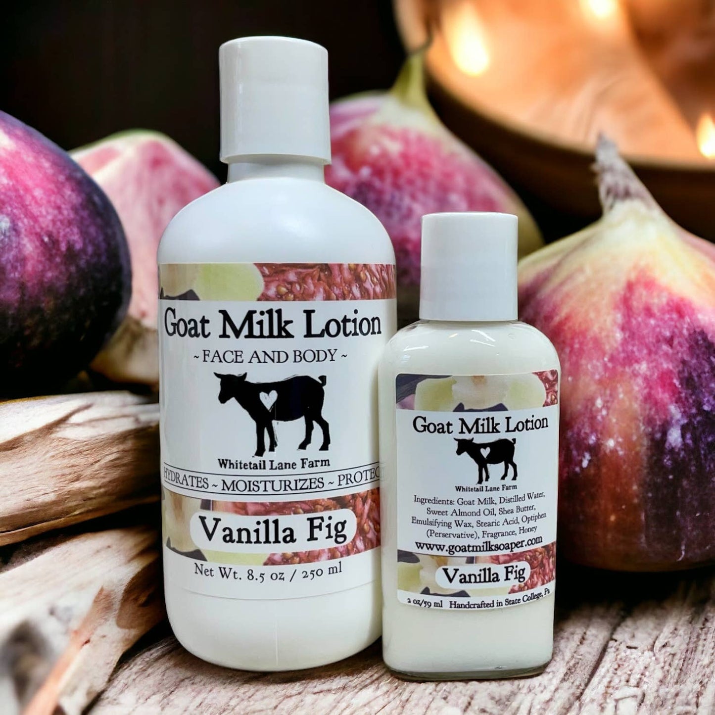 Two bottles of Vanilla Fig Goat Milk Lotion on a wooden surface with figs in the background.