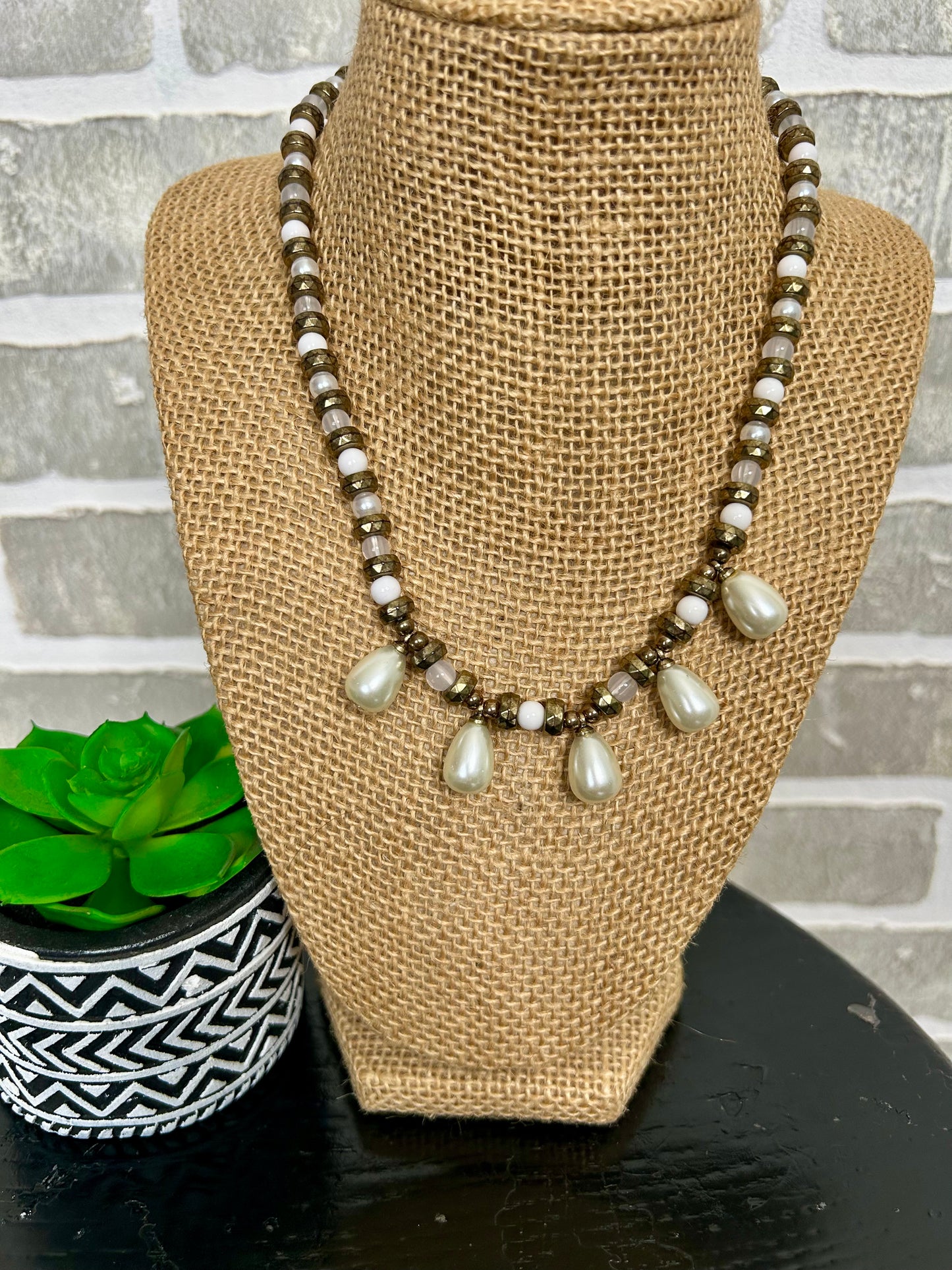 . This unique piece features layered beads of different shapes, adorned with 5 teardrop pearly stones. Combining beauty and classic style, this necklace is sure to make a statement. Elevate any outfit with this must-have accessory.
approx. 7.5' hanging length plus 2.5" extender