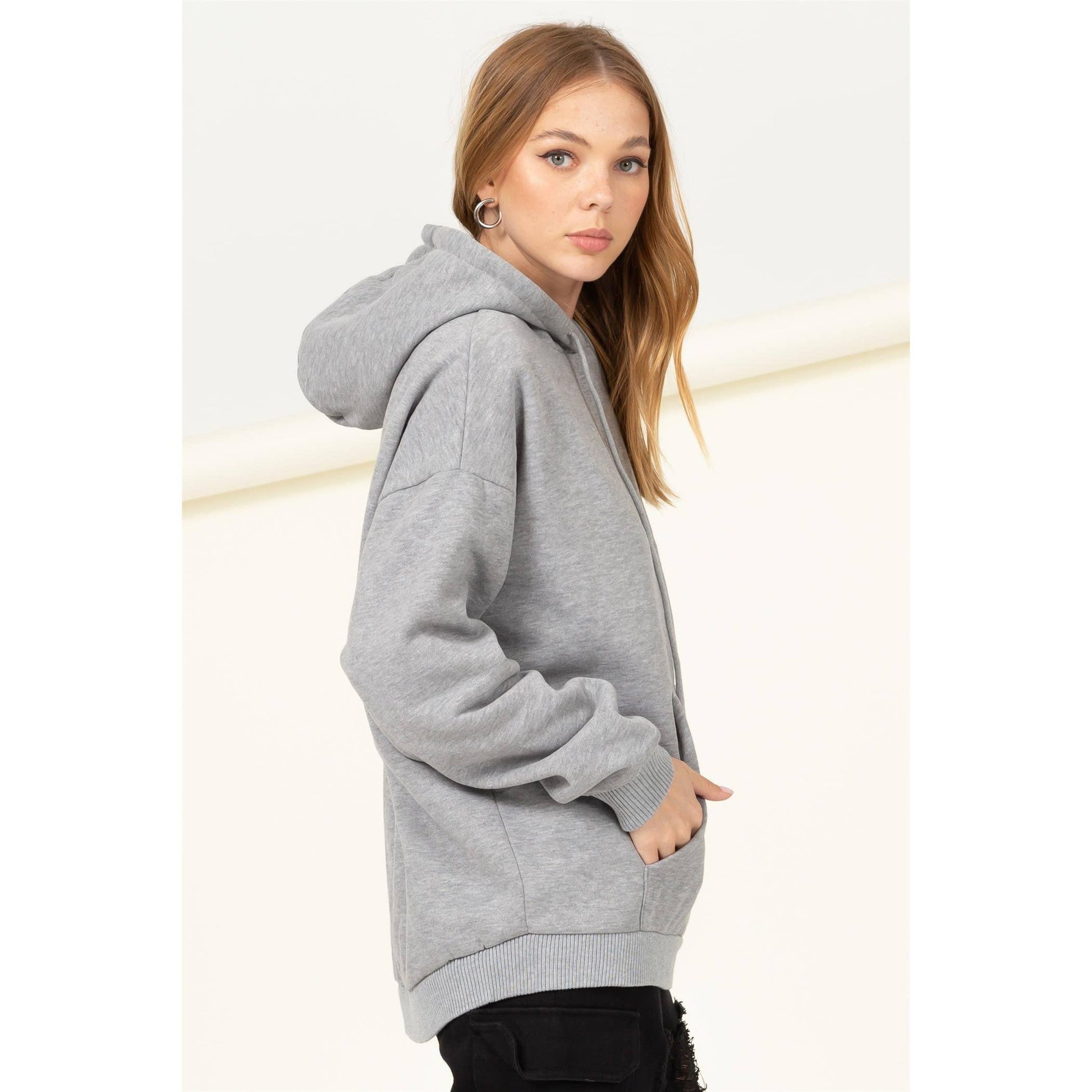 Woman wearing a gray hoodie on a white background