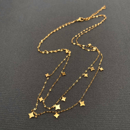 Gold necklace with star pendants on a dark gray background