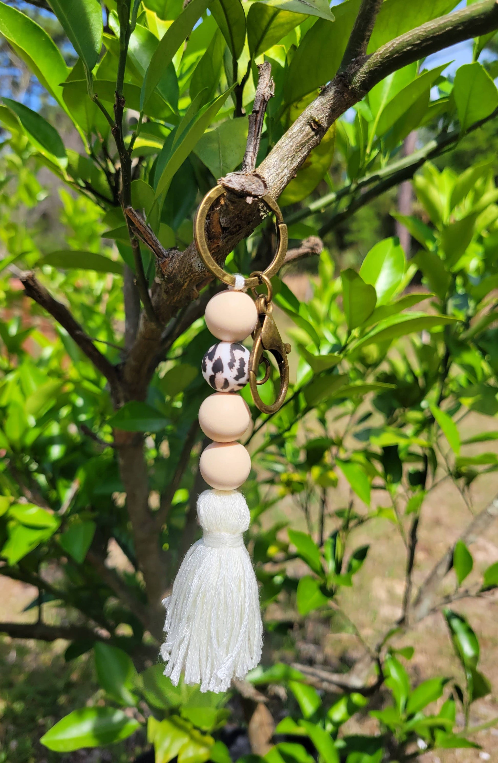 Boho Silicone Keychain - cream and leopard hanging in a tree