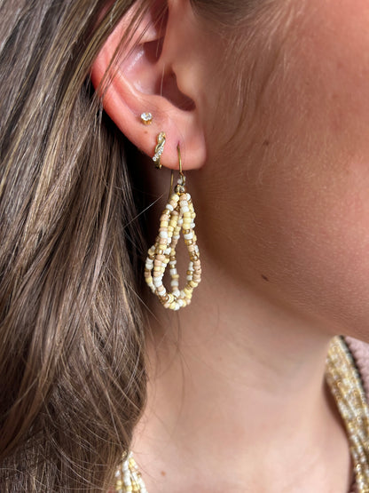 Close-up of an ear with pearl earrings and a blurred background