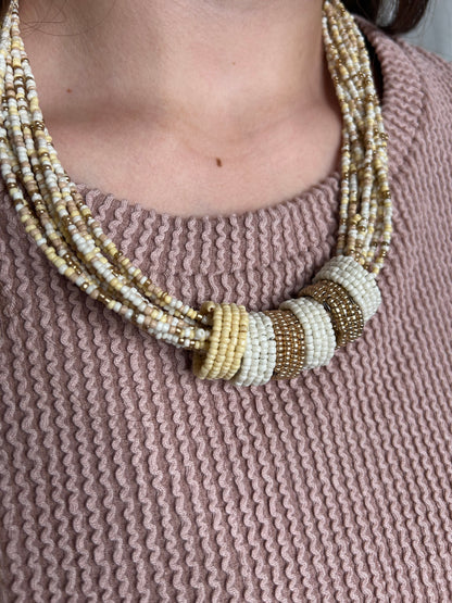 Close-up of a person wearing a beaded bracelet on a textured pink background