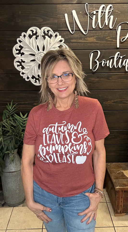 woman wearing a rust graphic tee in front of a decorative wall
