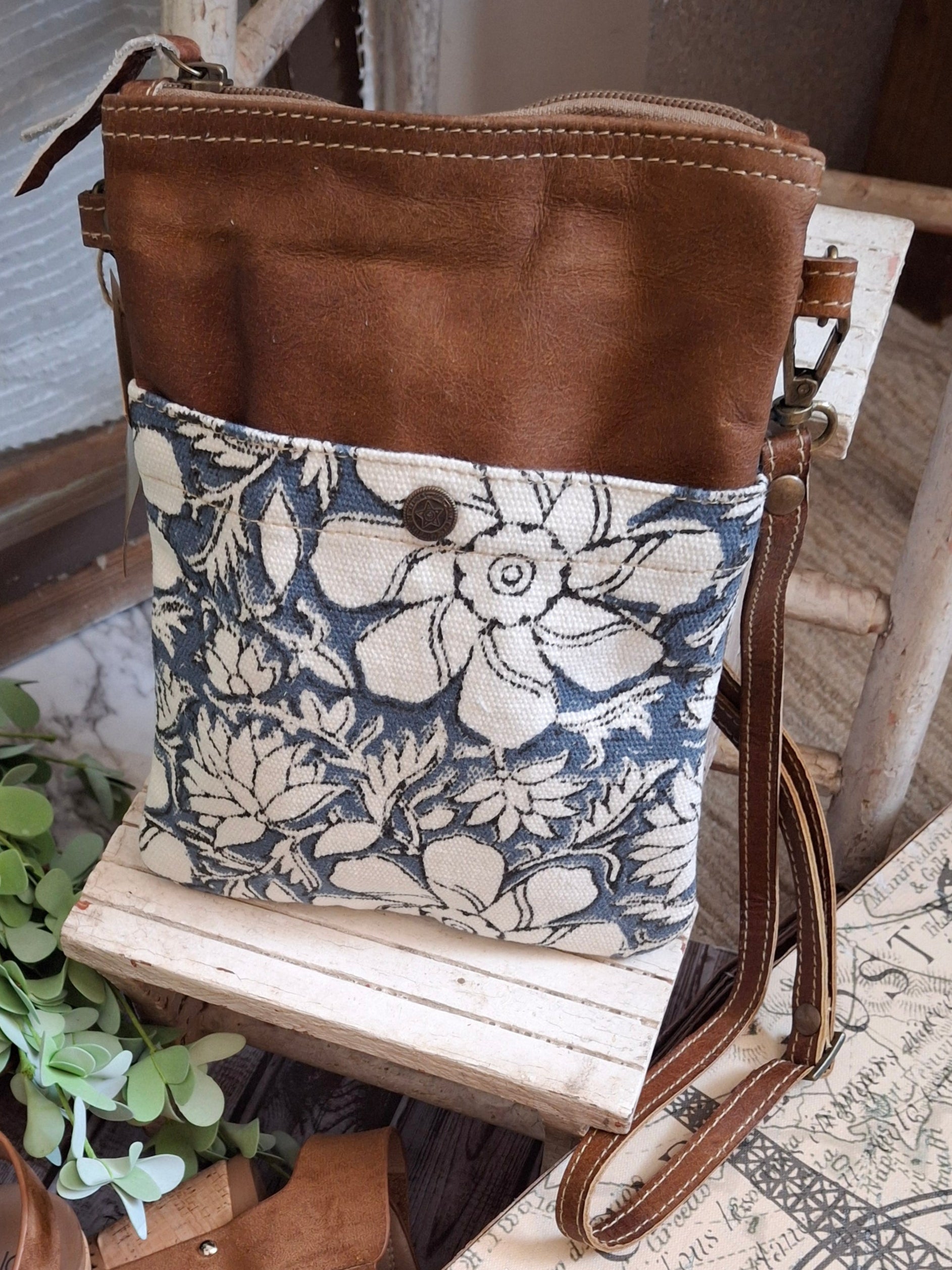 Whether you're navigating the urban jungle or heading out for a weekend getaway, this crossbody bag will keep your essentials secure while adding a touch of rugged elegance to your ensemble. It features a vintage blue and white stripe lining, two outside pockets, and an adjustable shoulder strap.&nbsp;

Designed &amp; Manufactured in USA/Hand Crafted