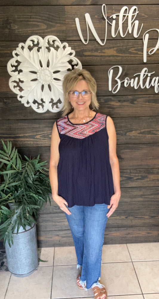 Stay cool and comfortable with the Boho Relaxed Navy Tank. Its relaxed fit and breathable fabric create an easy, breezy feel perfect for warm days. The crochet style inset with a mix of pinks, reds, blues, grays, and more, adds a colorful, stylish touch to any casual outfit. Effortless style meets comfort in this must-have summer essential. Pairs easily with denim, whites and more!&nbsp;

fits relaxed, consider sizing down 1/&nbsp; &nbsp;95%Rayon/5%Sandex