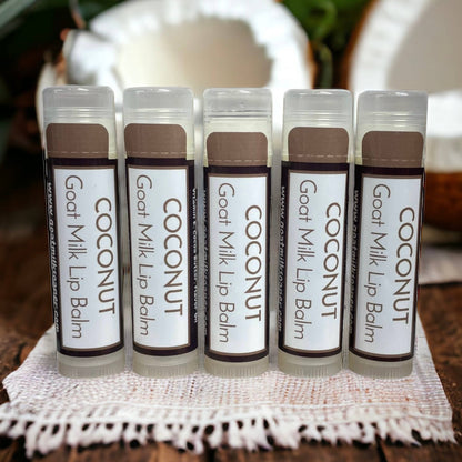Five tubes of Coconut Goat Milk Lip Balm on a white doily with a blurred background.