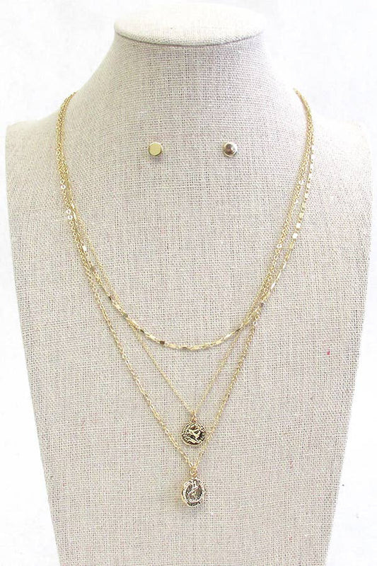Set of gold  coin necklaces and earrings on a mannequin bust.