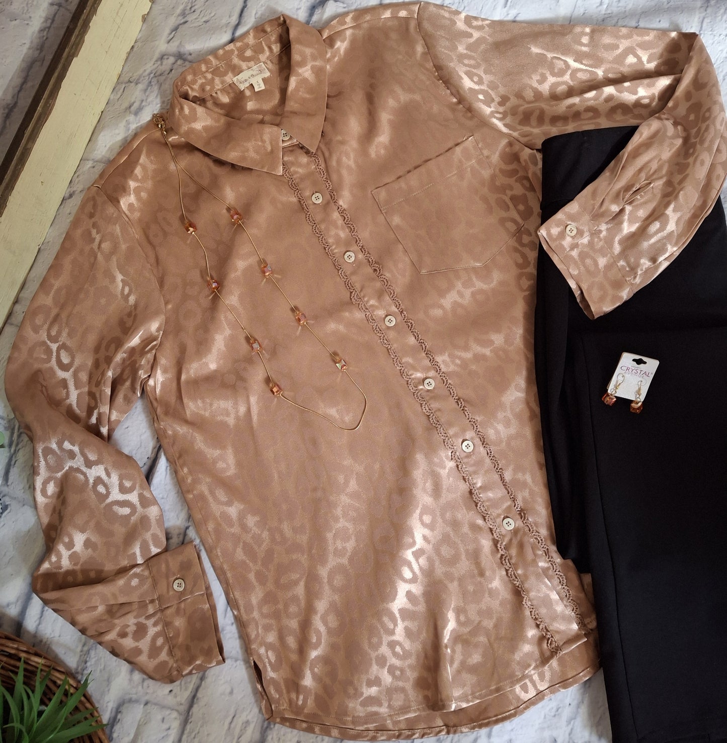 Champagne animal print blouse with black pants on a white background