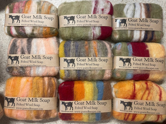 Grid of colorful goat milk soap bars with visible branding and labels.