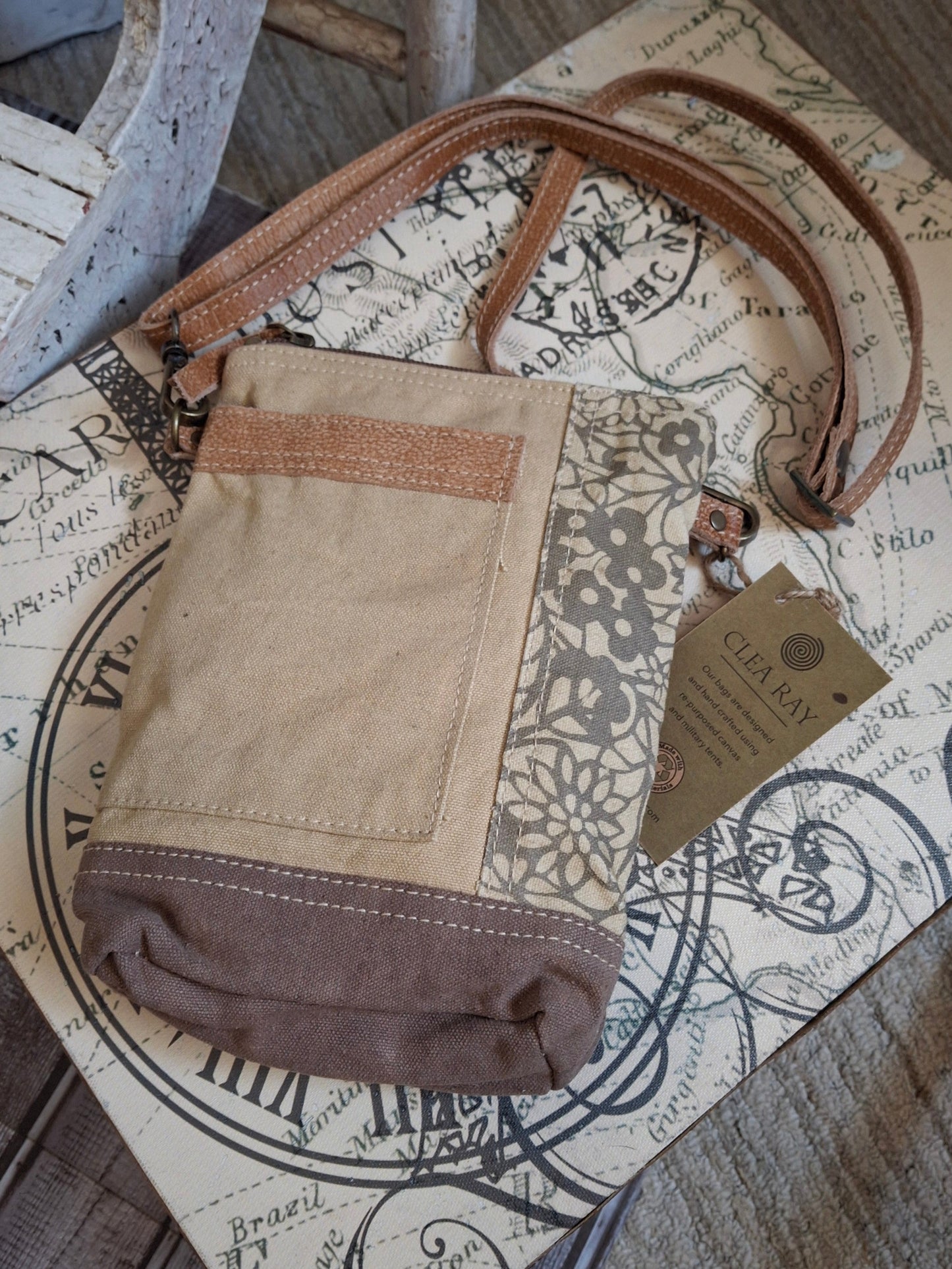 This easygoing crossbody goes with everything! It stays retro with its flower embossed side panel.&nbsp; The neutral colors will pair with any outfit and its size is just perfect for your essentials.&nbsp; It features a vintage blue and white stripe lining, one outside pocket and an adjustable shoulder strap.&nbsp;
