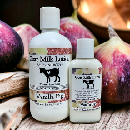 Two bottles of Vanilla Fig Goat Milk Lotion on a wooden surface with figs in the background.