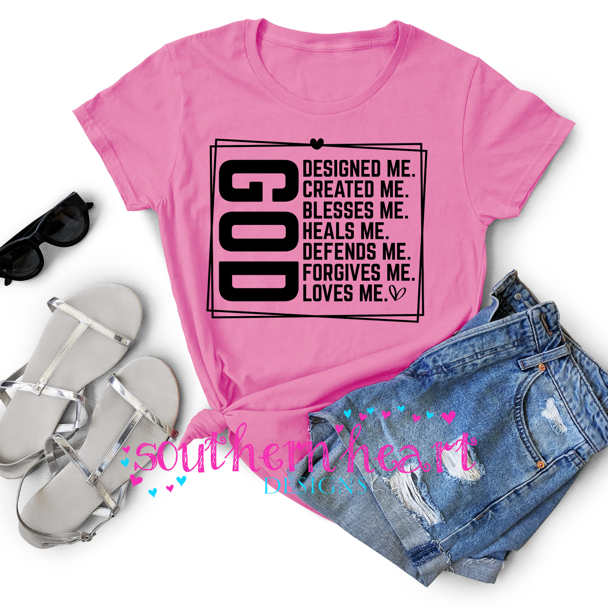 Pink t-shirt with motivational text, sunglasses, sandals, and shorts on a white background