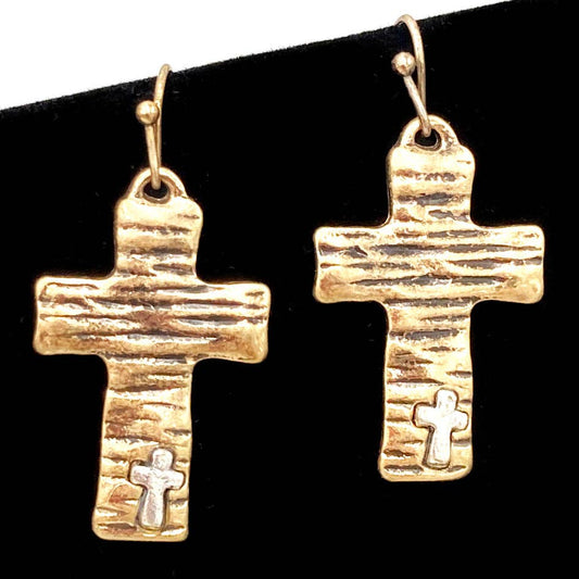 Gold cross-shaped earrings on a black background