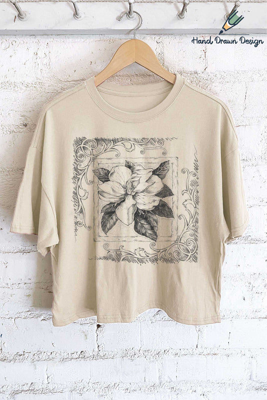 This relaxed, boxy, slightly cropped tee is made with soft cotton &amp; features a classic crew neckline with a timeless hand-drawn magnolia graphic. Its neutral colors make it easy to pair with any outfit, while the simple yet beautiful design adds a special, playful flair to your look. Perfect for those who love effortless style with a unique touch.

;Made from 100% cotton. Soft dyed and designed in the US. * * Care instructions * * - The best way to preserve the design is to wash with a mild deterge