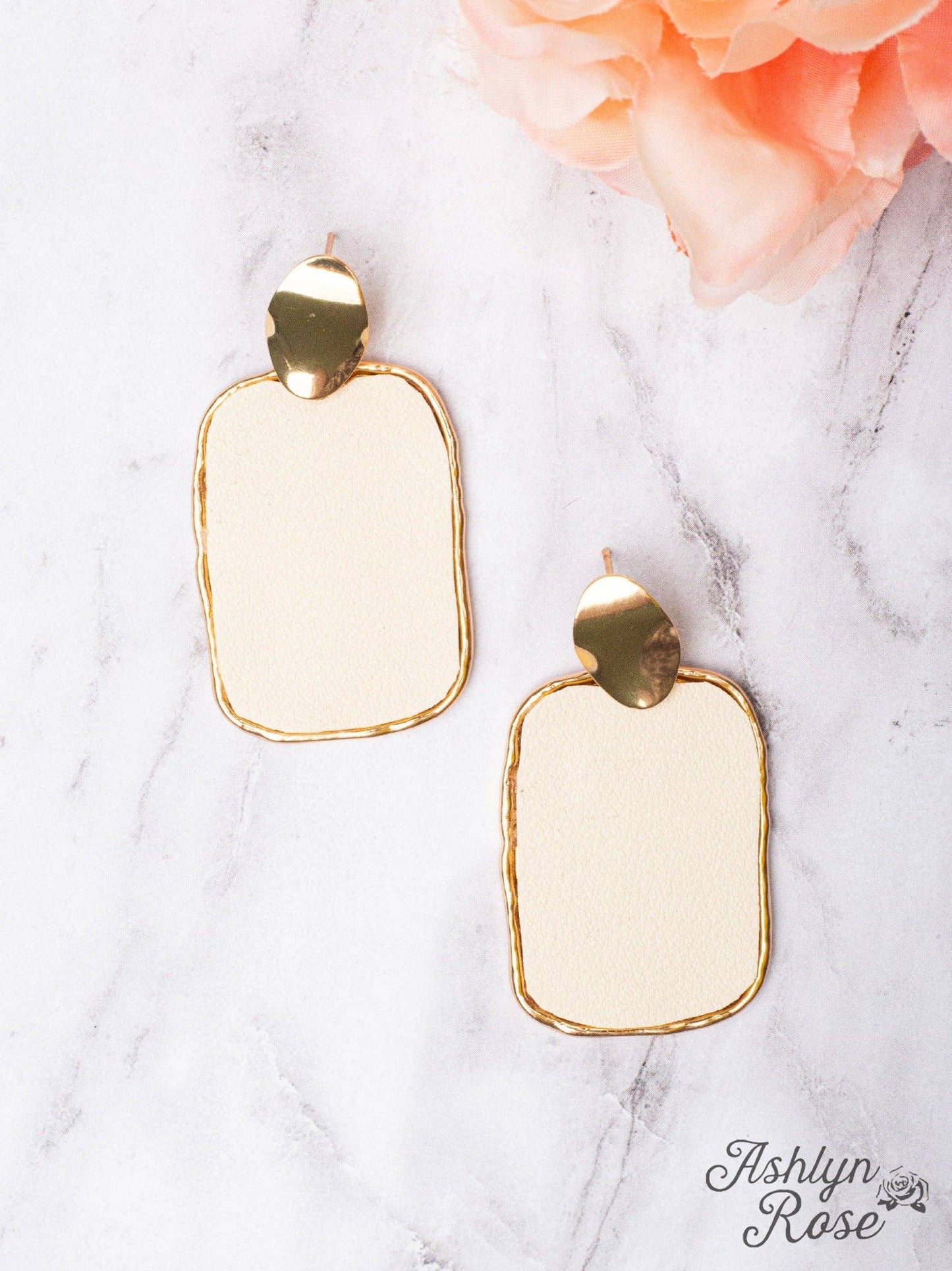 faux leather rectangle ivory earrings trimmed in gold, stud on a white background