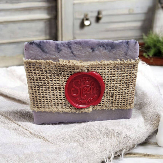 Bar of soap in a burlap container with a red logo on a textured surface