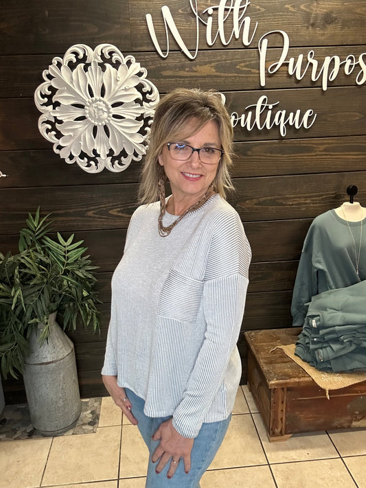 women wearing a grey ribbed boxy fit long sleeve top