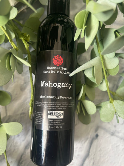Bottle of Mahogany Goat Milk lotion with a green leafy background
