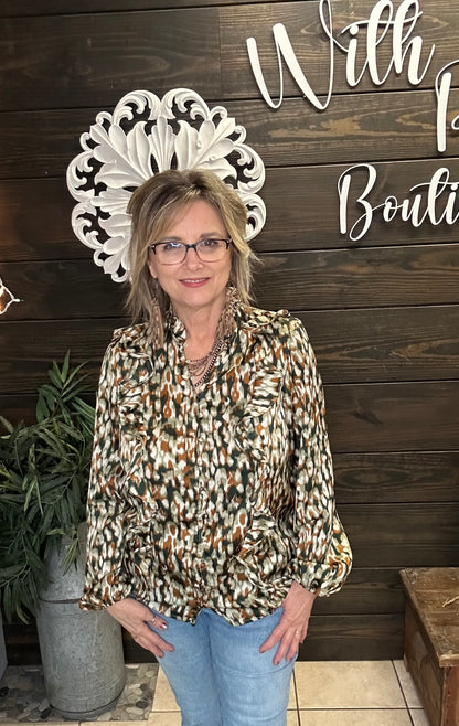 Woman standing in front of a wooden wall wearing a multicolored fall blouse, with decorative elements and text.