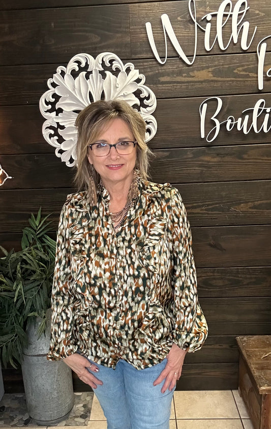 Woman standing in front of a wooden wall wearing a multicolored fall blouse, with decorative elements and text.