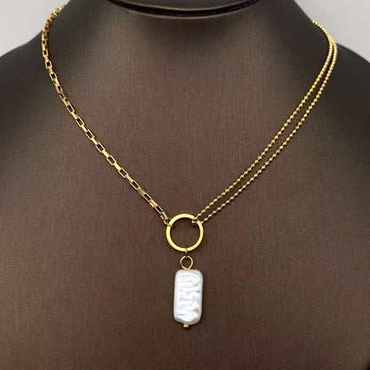 Gold necklace with a white pearl pendant on a mannequin