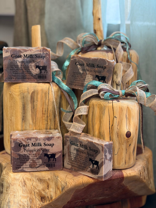 Goat milk soap bars on wooden pumpkins with ribbons