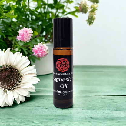 Roll-on bottle of magnesium oil from Steele Family Farm on a wooden surface with flowers in the background.