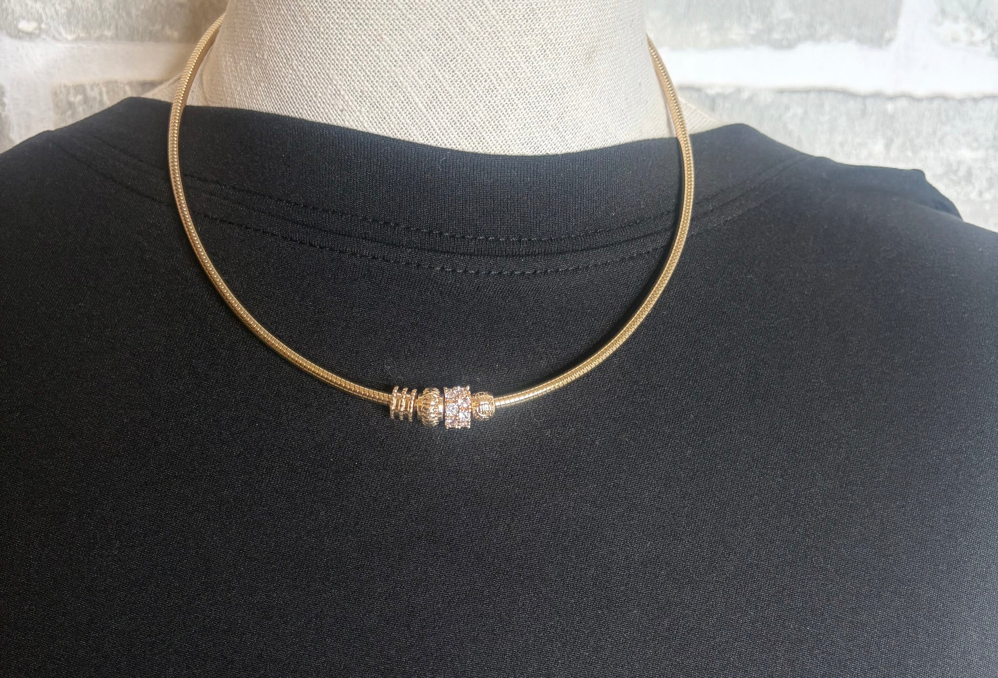 Necklace with a decorative charms on a black mannequin