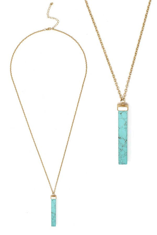 Necklace with turquoise bar pendants on gold chains against a white background