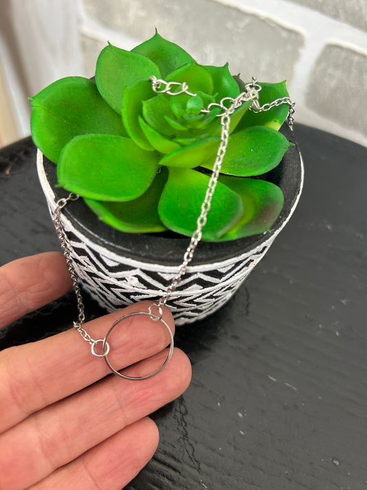 Silver tone necklace with a Small Silver circle disc.
Approx. 10" + 2.5" extender