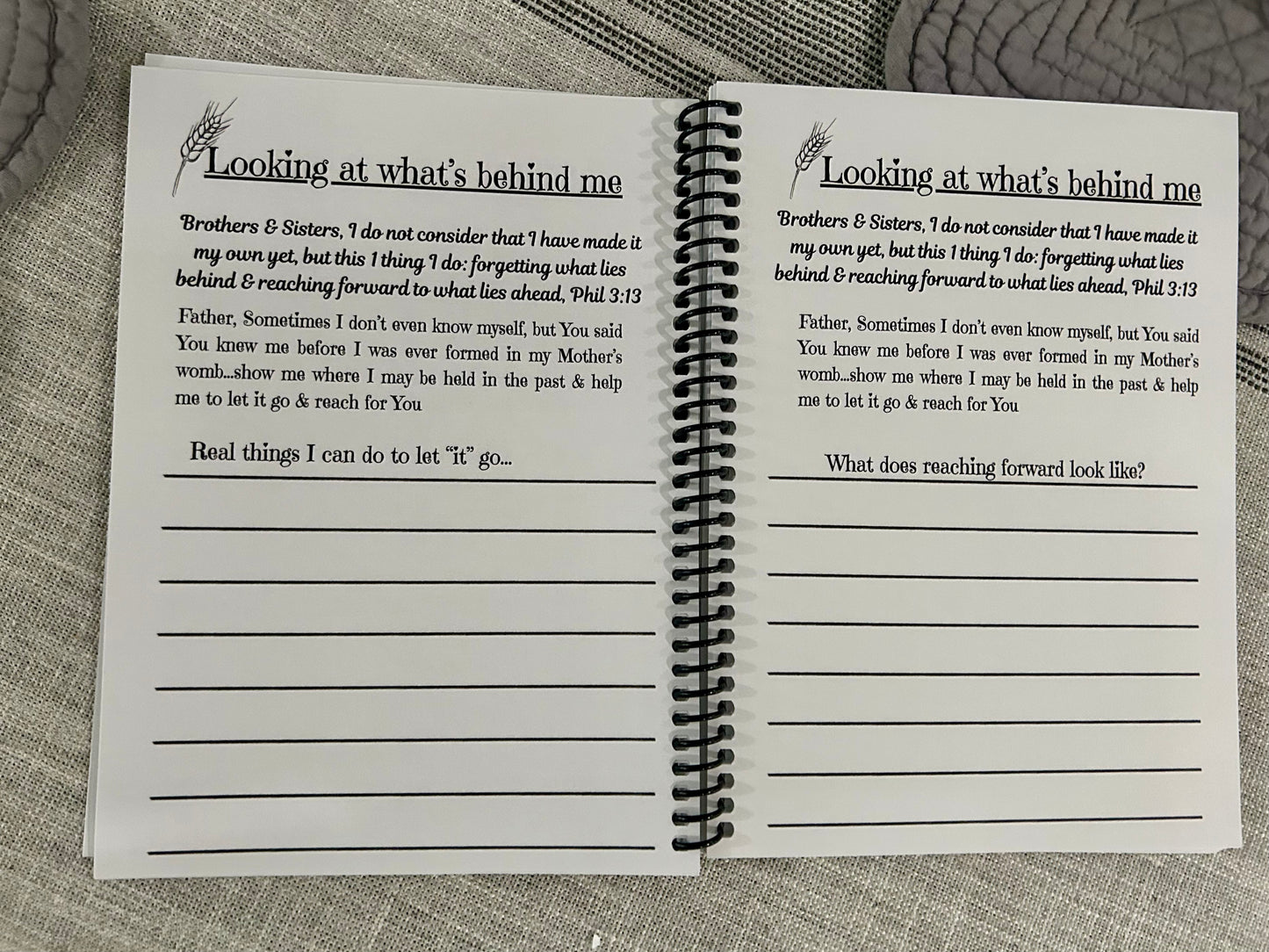 Open spiral-bound notebook with printed text about not looking back