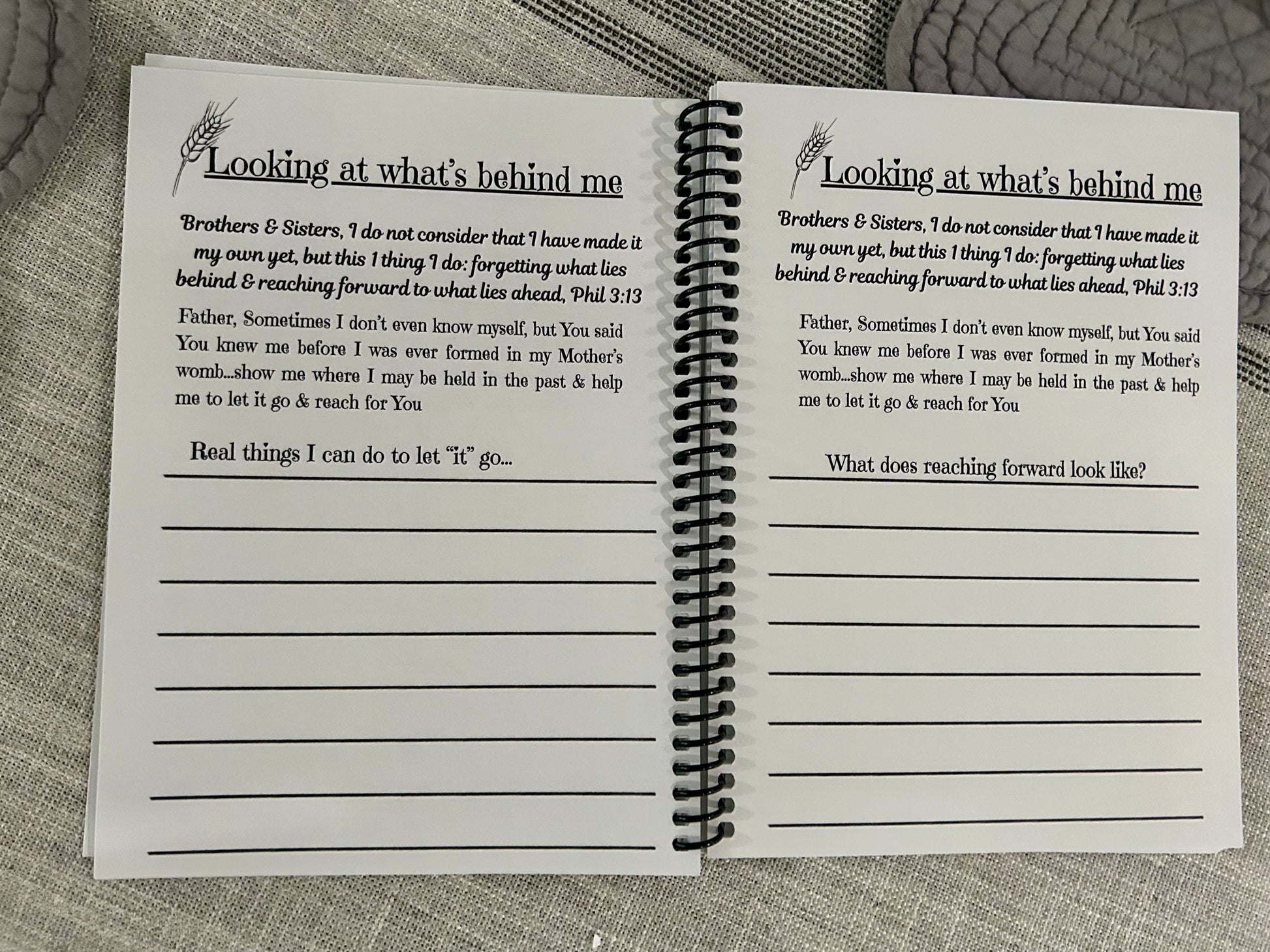 Open spiral-bound notebook with printed text about not looking back