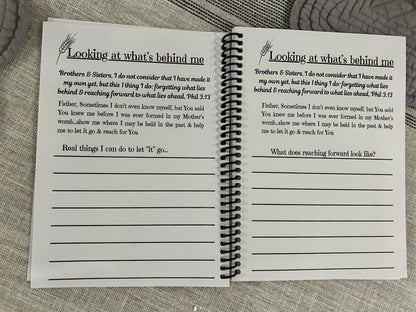 Open spiral-bound notebook with printed text about not looking back