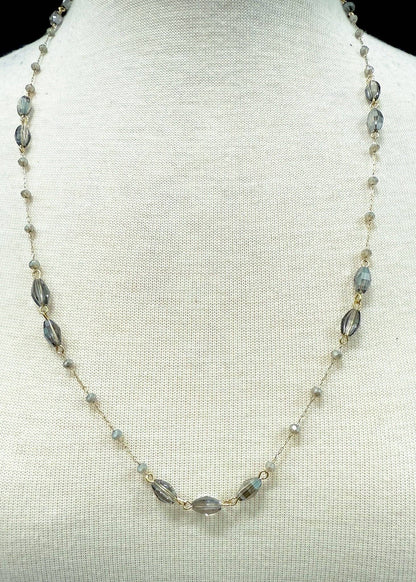 Necklace with gray & amber beads on a mannequin bust against a light background