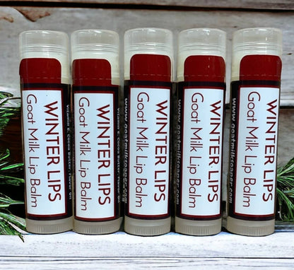 Six lip balms labeled 'Winter Lips Goat Milk Lip Balm' on a wooden surface.