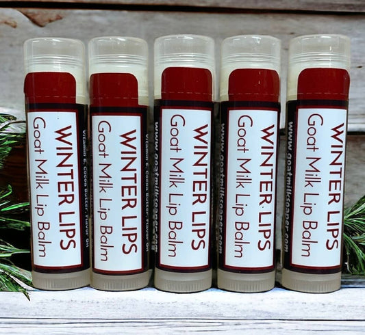 Six lip balms labeled 'Winter Lips Goat Milk Lip Balm' on a wooden surface.