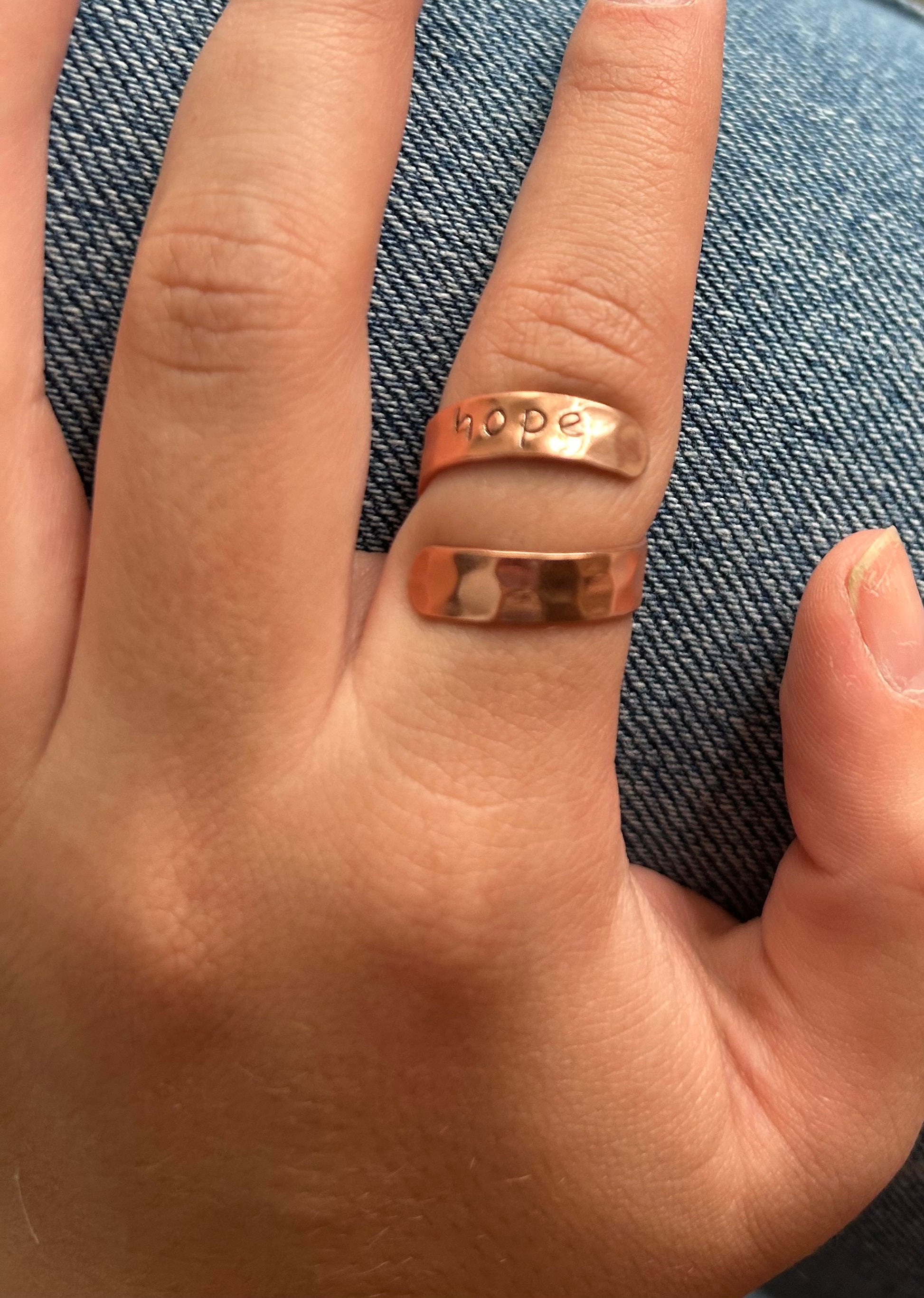 copper colored ring with the word hope engraved in it. adjustable 