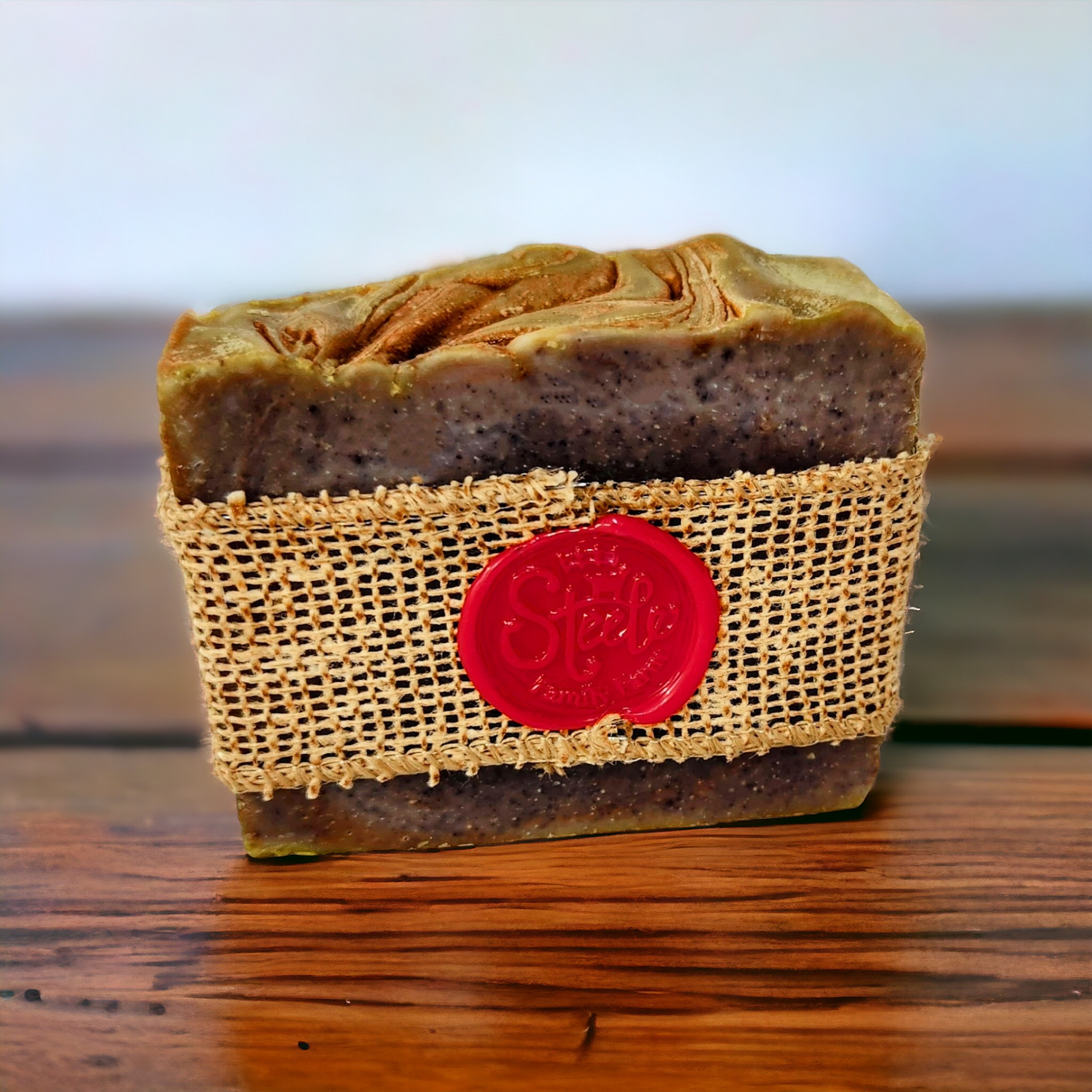 Bar of soap wrapped in burlap with a red label on a wooden surface