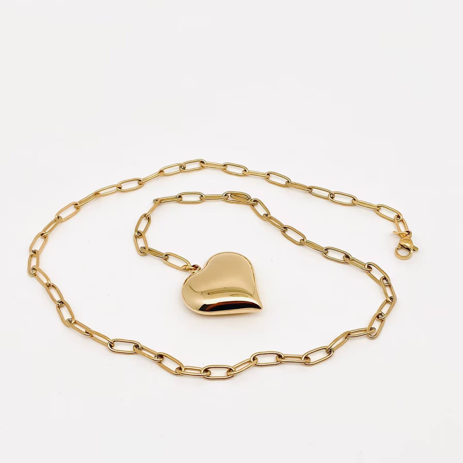 Gold heart-shaped padlock on a gold chain against a white background