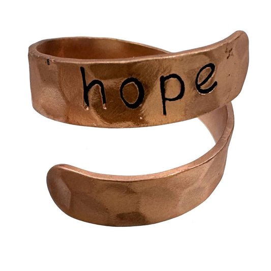 Copper ring with 'hope' engraved on a white background