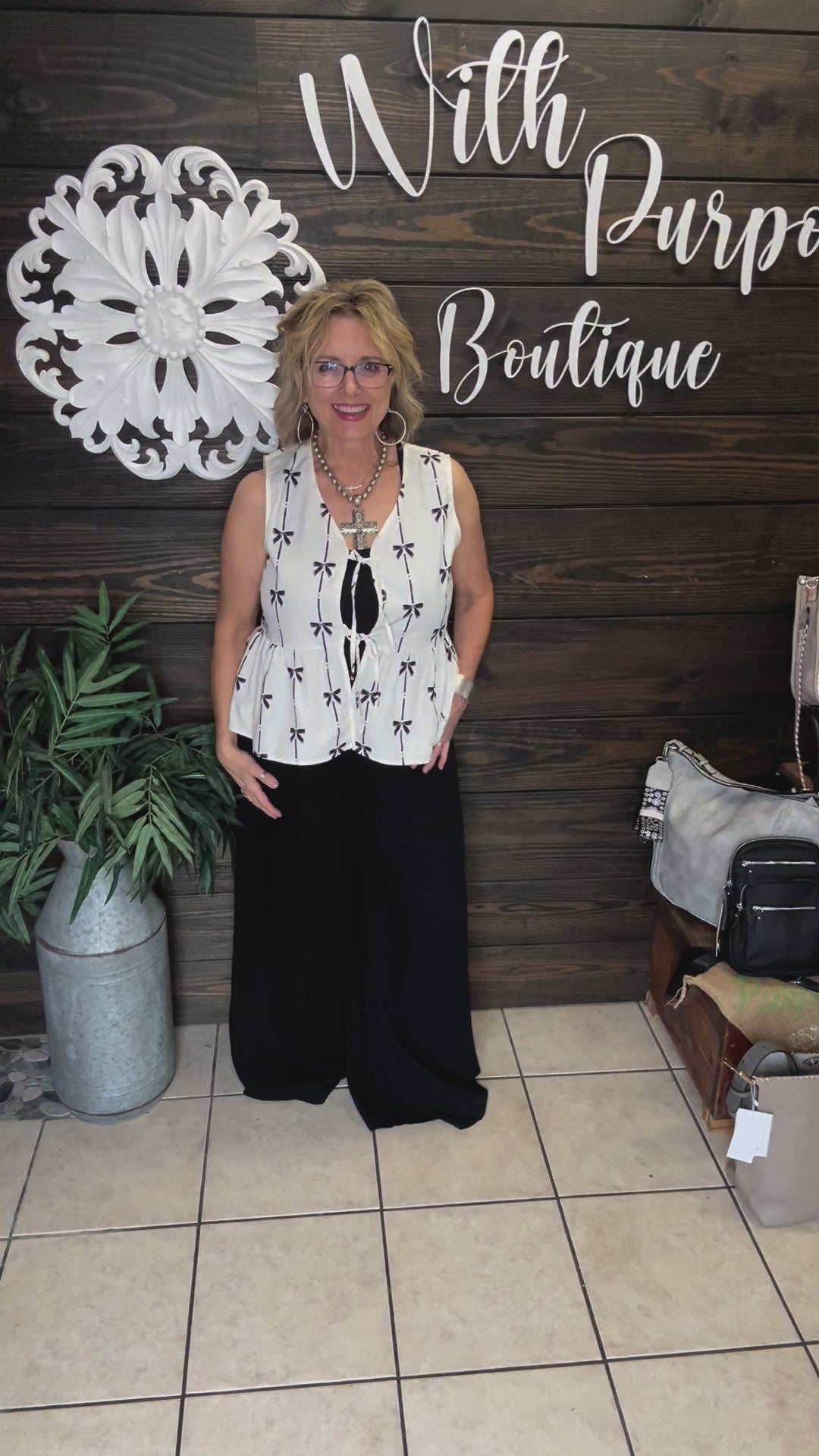 100% polyester cream colored vest with printed black bows, 2 ties in front to add to look, sleeveless. 